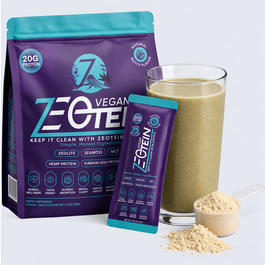 A Zeotein Vegan protein bag and single serve stick pack beside a glass of blended smoothie and a scoop of powder
