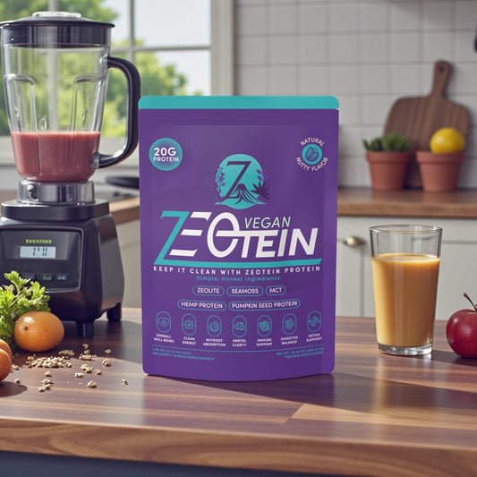 A Zeotein Vegan protein bag on a kitchen counter beside a blender and a glass of freshly blended smoothie